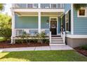 Charming front porch with seating area, featuring a blue exterior and classic black front door at 2627 Rutherford Way, Charleston, SC 29414