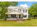 Charming two-story home with a covered porch, complemented by lush green lawn and mature trees at 285 Roosevelt Dr, Saint Stephen, SC 29479
