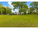 Expansive front yard featuring mature trees, complemented by a charming home in the background at 285 Roosevelt Dr, Saint Stephen, SC 29479