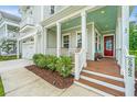Inviting front porch with a red door, classic columns, and a teal-painted ceiling for added charm at 2962 Clearwater Dr, Mount Pleasant, SC 29466