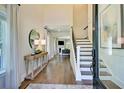 Elegant entryway with hardwood floors, staircase, stylish mirror, and decor leading into a brightly lit living space at 3307 Sawlog Dr, Summerville, SC 29486
