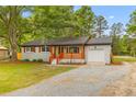Inviting one-story home boasts a brick exterior, a wooden porch, and a spacious gravel driveway at 346 Horseshoe Rd, Moncks Corner, SC 29461