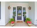 Charming front entrance adorned with potted plants, a wreath, and stylish outdoor lighting at 3587 Goodwater St, Mount Pleasant, SC 29466