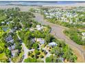 Expansive aerial view of a residential area bordered by tranquil waters and lush landscapes, showcasing community charm and natural beauty at 380 Tidal Reef Cir, Mount Pleasant, SC 29464