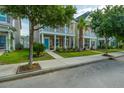 Charming two-story home with a welcoming front porch, lush green lawn, and mature trees lining the street at 422 Verbena Ave, Summerville, SC 29483