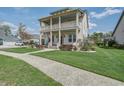 Beautiful two-story home boasting a double front porch and lush green lawn at 4303 Misty Hollow Ln, Ravenel, SC 29470