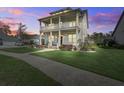 Lovely two-story home featuring double front porches at dusk with a well-kept lawn at 4303 Misty Hollow Ln, Ravenel, SC 29470