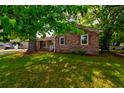 A single-story brick home with a lush green lawn and mature shade trees around the property at 4327 Bream Rd, North Charleston, SC 29418
