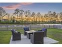 Backyard patio featuring an outdoor seating area with comfortable chairs and a table, perfect for enjoying the sunset at 555 Dunswell Dr, Summerville, SC 29486