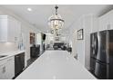 Kitchen island with white countertop and stainless steel appliances, open to the dining and living areas at 555 Dunswell Dr, Summerville, SC 29486