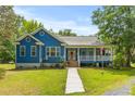 Well-maintained blue home with a welcoming front porch, showcasing a blend of comfort and classic design at 6035 Bay Pond Rd, Ravenel, SC 29470