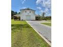 Well-maintained home with a long gravel driveway, showcasing its modern design and landscaping at 795 Shagule Rd, Edisto Island, SC 29438