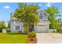 Lovely two-story home with a one-car garage, bright yellow front door and manicured landscaping at 828 Williamsburg Ln, Charleston, SC 29414