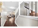 Inviting entryway featuring wood floors, a staircase with wrought iron railings, and a view into the living room at 8676 Grassy Oak Trl, North Charleston, SC 29420
