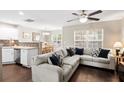Comfortable living room that showcases a large sectional sofa, dining area, and dark hardwood floors at 8676 Grassy Oak Trl, North Charleston, SC 29420