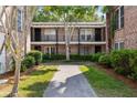 A quaint brick building with lush landscaping and a concrete walkway at 870 Colony Dr # 14, Charleston, SC 29407