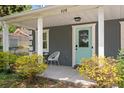 Inviting front porch with seating, decorative plants, and a stylish aqua-colored front door at 928 Sycamore Ave, Charleston, SC 29407