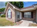 Close up view of a charming brick home with tan vinyl siding and a well-kept lawn at 9630 N Cardinal Dr, Ladson, SC 29456