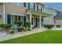 Inviting front porch with decorative plants and an American flag, adding charm and curb appeal at 9636 Pebble Creek Blvd, Summerville, SC 29485