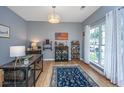 Stylish home office with hardwood floors, a large window, and a custom bar area at 9636 Pebble Creek Blvd, Summerville, SC 29485