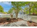 Charming home with a white picket fence, lush landscaping, and a Little Free Library at 9666 Jamison Rd, Ladson, SC 29456