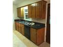 Functional kitchen featuring wood cabinets, black appliances, and a double basin sink at 1010 Foxcroft Rd, Charleston, SC 29412