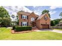 Charming two-story brick home featuring a well-manicured lawn, flowering plants, and a welcoming entrance at 102 Six Point Ct, Goose Creek, SC 29445