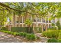 Stately two-story home with a double porch and wrought iron railings, enhanced by mature trees and landscaping at 121 W Shipyard Rd, Mount Pleasant, SC 29464