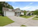 A gray, single-Gathering home with a two-car garage, an orange door, and a well-kept lawn at 1221 Lois Allen Rd, Johns Island, SC 29455