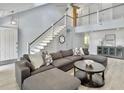 Bright, open-concept living area features soaring ceilings, modern staircase, and stylish gray sectional sofa at 1410 Diamond Boulevard, Mount Pleasant, SC 29466
