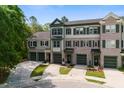 The townhome boasts a well-maintained front exterior with garages and charming brick and siding details at 148 Cowrie Ct, Mount Pleasant, SC 29464