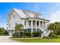 Elegant home with a metal roof, front porch, manicured lawn, and multi-car garage at 1500 Bower Ln, Johns Island, SC 29455
