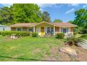 Attractive home with brick accents, yellow door and siding, and a lush green lawn at 1575 Langston Dr, Johns Island, SC 29455