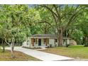 Inviting white brick home with a long driveway and lush landscaping, creating a welcoming curb appeal at 1621 Point Park Dr, Johns Island, SC 29455