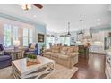 Bright open-concept living room featuring stylish furnishings, hardwood floors, and seamless connection to dining and kitchen at 1776 W Canning Dr, Mount Pleasant, SC 29466