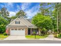Lovely brick home with well-kept lawn, inviting front porch with rocking chairs and a two-car garage at 184 Angora Way, Summerville, SC 29485