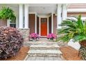 Charming front porch with stone accents, decorative plants, and vibrant flowers at 2017 Woodland Shores Rd, Charleston, SC 29412
