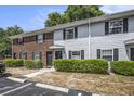 Exterior view of townhomes featuring brick and gray siding, complemented by lush green landscaping and ample parking at 21 Rivers Point Row # 3C, Charleston, SC 29412