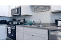 Kitchen featuring stainless steel appliances, white cabinets, and a double basin sink at 224 Coral Sunset Way, Summerville, SC 29486