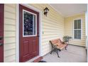 Close up of a welcoming front porch with a decorative glass paneled door and seating area at 249 Old Savannah Dr, Goose Creek, SC 29445