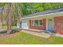 A charming brick home with a manicured lawn and a quaint, welcoming front entrance at 2736 Shadow Ln, North Charleston, SC 29406