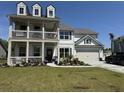 Charming two-story home with inviting front porch, manicured lawn, and attached two car garage at 3173 Hugh Bennett Dr, Johns Island, SC 29455