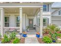 Inviting front porch with plants, seating, and a decorative wreath on the gray front door at 3173 Hugh Bennett Dr, Johns Island, SC 29455