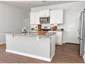 Modern kitchen featuring white cabinets, stainless steel appliances, and a spacious island with granite countertop at 323 Bear Paw Ln, Summerville, SC 29486