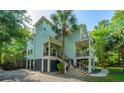 Elegant two-story home with double balconies, surrounded by palm trees, perfect for serene, coastal living at 3738 Station Point Ct, Mount Pleasant, SC 29466