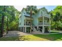 Stylish two-story home featuring double balconies, set amidst lush trees, evoking a tranquil, seaside atmosphere at 3738 Station Point Ct, Mount Pleasant, SC 29466
