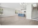 Bright and airy living room with hardwood floors, a blue island, and a staircase at 399 Claret Cup Way, Charleston, SC 29414