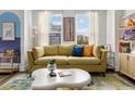 Cozy living room featuring a comfortable yellow sofa, stylish decor, and plenty of natural light at 4585 Summey St, North Charleston, SC 29405
