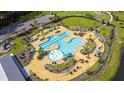 Aerial view of a resort-style pool with sun loungers, cabanas, and lush landscaping in a planned community at 527 Verdi Drive Dr, Summerville, SC 29486