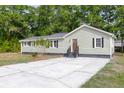 Charming single-story home with light green siding and dark trim plus a gray roof and a concrete driveway at 5774 Scott White Rd, Hollywood, SC 29449